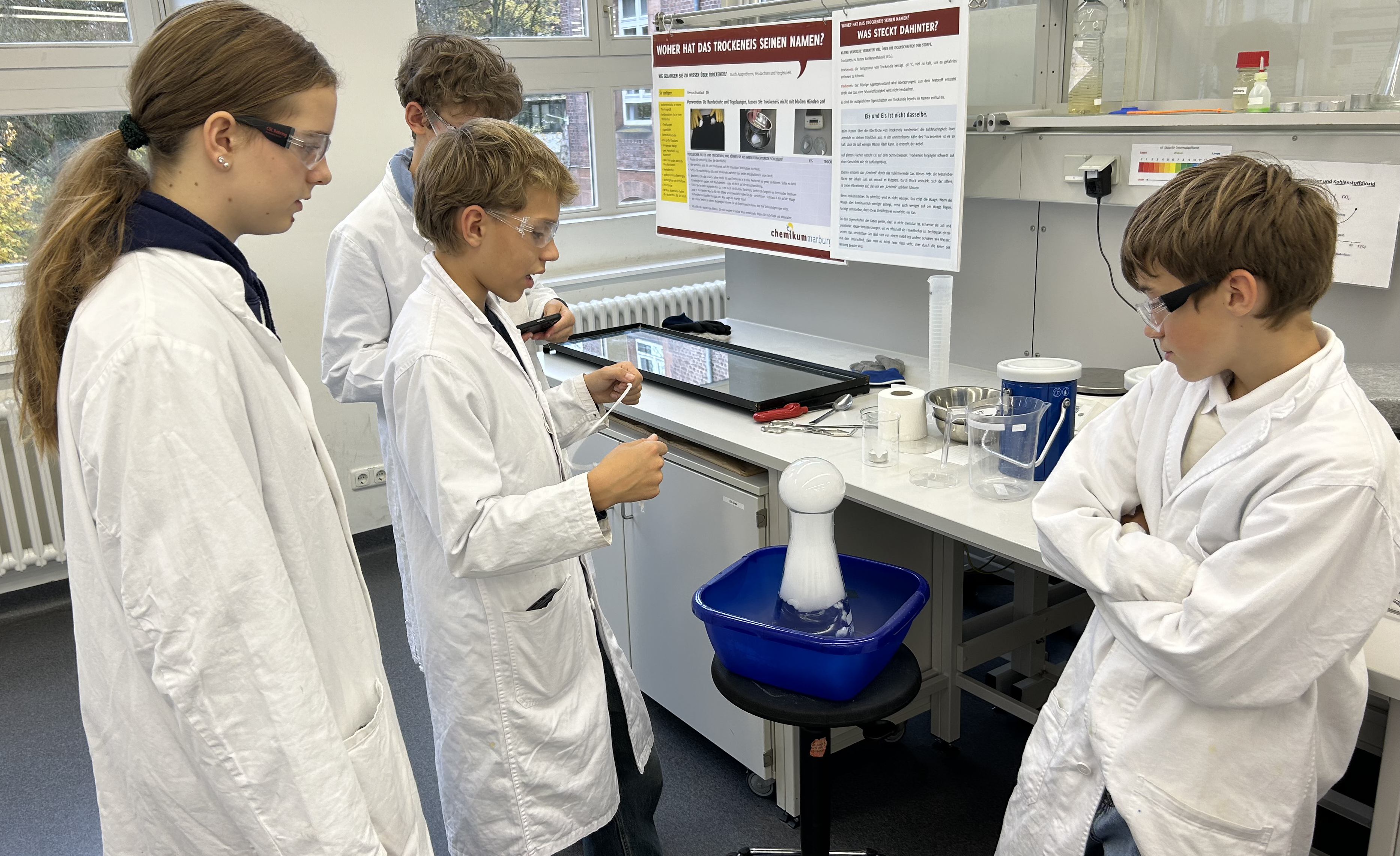 4 Schüler vor Trockeneis im Wasser